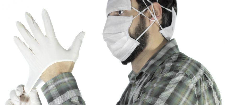 man is freaked out of coronavirus, face is completely covered with epidemic face mask, wearing latex surgical gloves